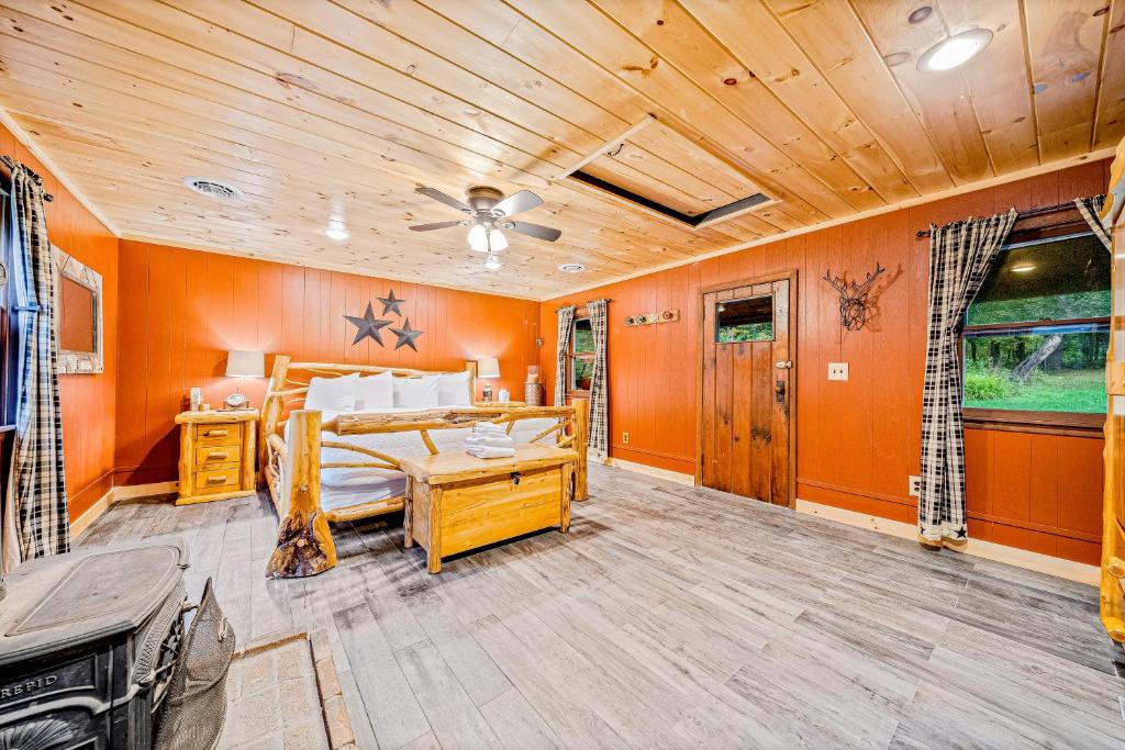 Schlafzimmer mit orangefarbenen Wänden, einem Bett und einer Decke in der Unterkunft Minerva's Log Cabin Gem in Minerva