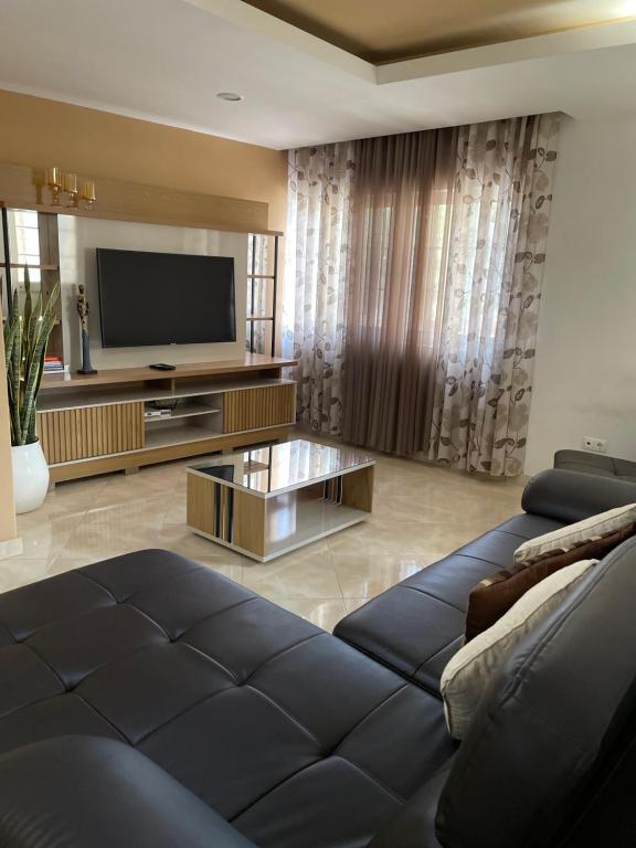 a living room with a couch and a television at Apartamentos Avenida in Praia