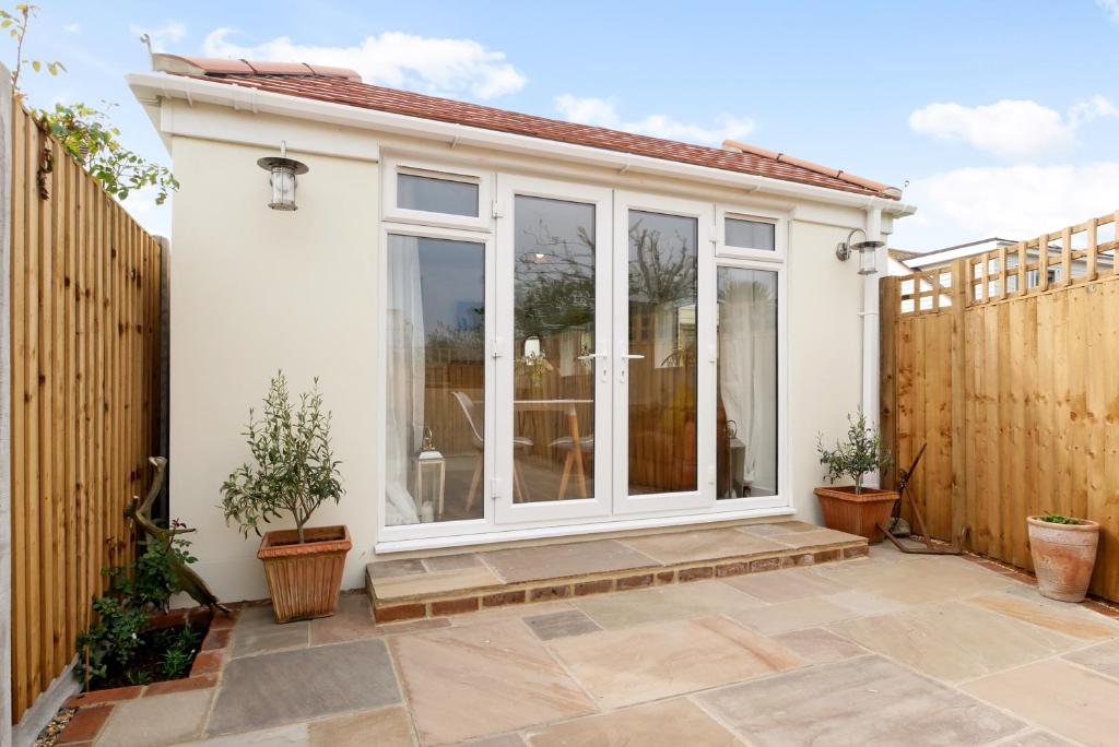 a garden room with sliding glass doors on a house at Seaside Annexe in Felpham