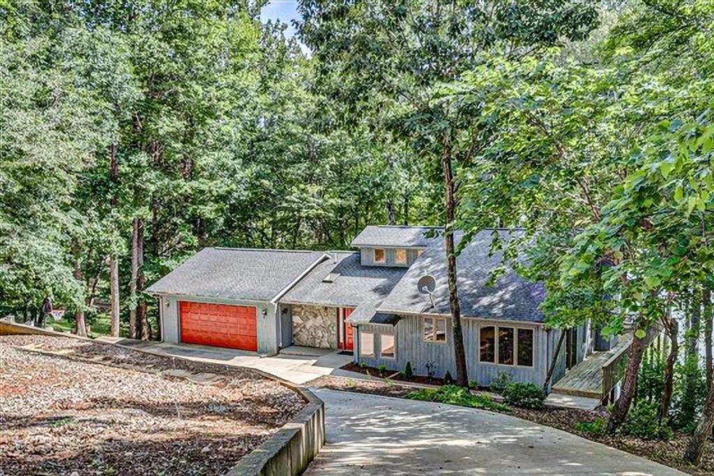 une maison avec un garage rouge dans les bois dans l'établissement A Kerr Home, à Moneta