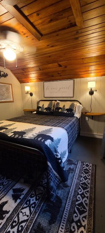 een slaapkamer met een bed in een kamer met houten plafonds bij Riverside Retreat in Hendersonville