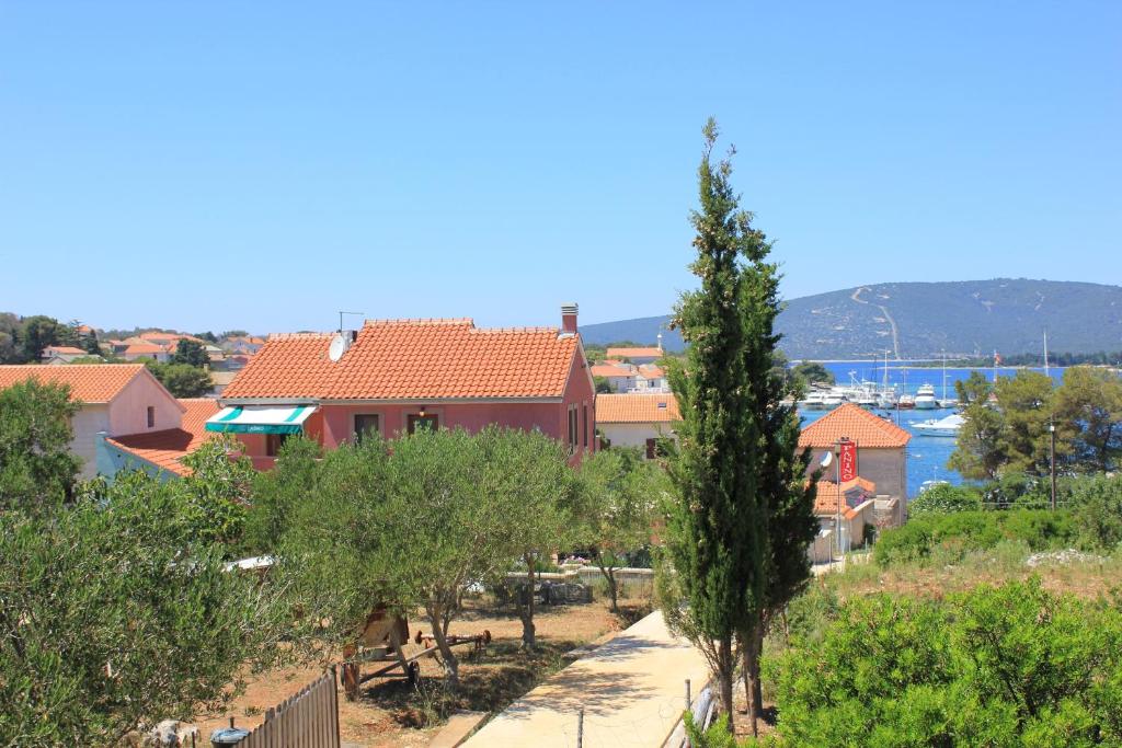 a view of a town with trees and a house at Apartments by the sea Ilovik, Losinj - 8069 in Ilovik