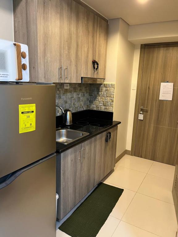 a small kitchen with a sink and a refrigerator at Coast Residences, Roxas Blvd, Pasay City in Manila