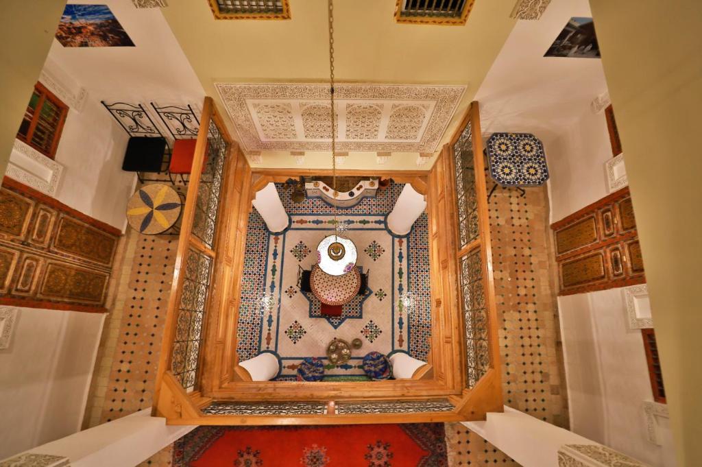 Zimmer mit einem marokkanischen Teppich und einem Zimmer mit einer Decke in der Unterkunft Riad Fes Unique in Fès