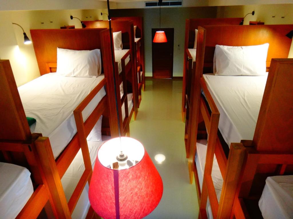 a room with three bunk beds and a red lamp at Phangan Pearl Hostel in Haad Rin
