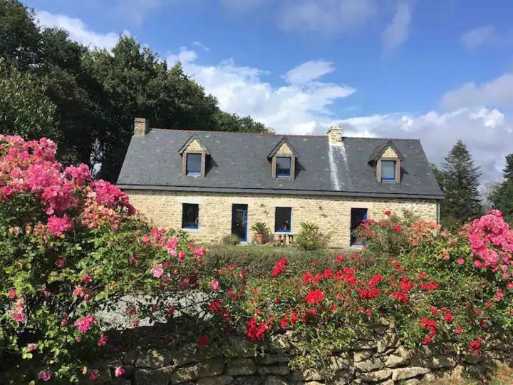 a stone house with flowers in front of it at TY Fine Rose in Riec-sur-Bélon