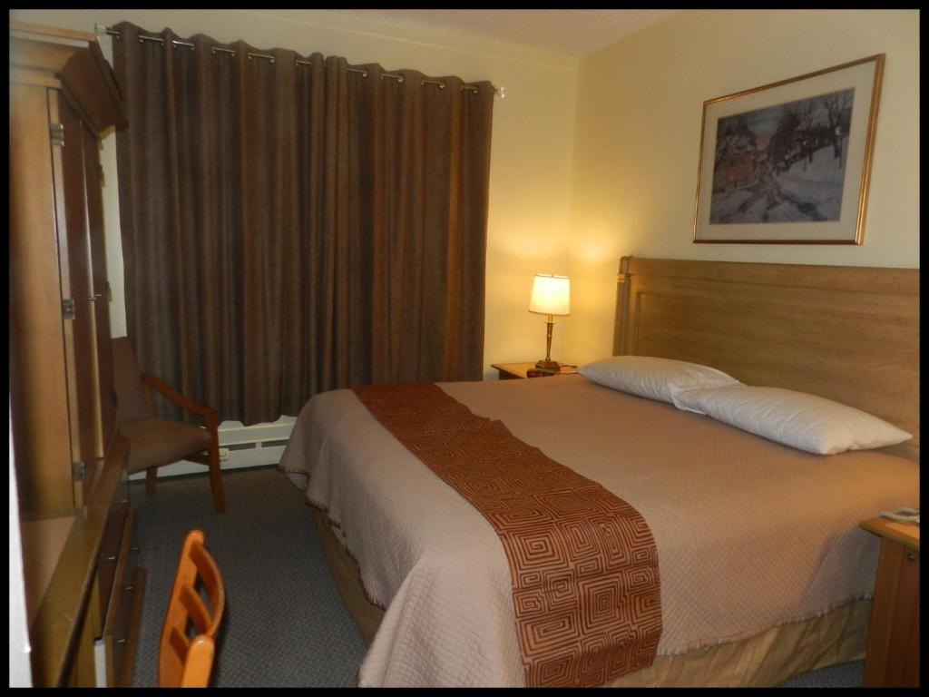 Postel nebo postele na pokoji v ubytování L'Auberge de l'Aeroport Inn