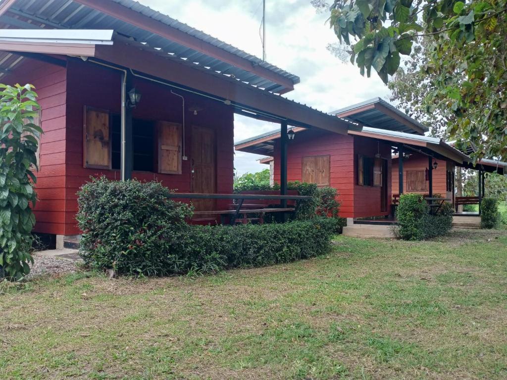 una casa roja con un patio delante en Sleep & fishing Pua, en Nan