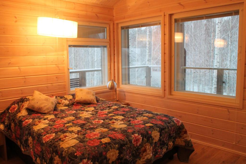 a bedroom with a bed and two windows at SResort Family Apartment in Imatra