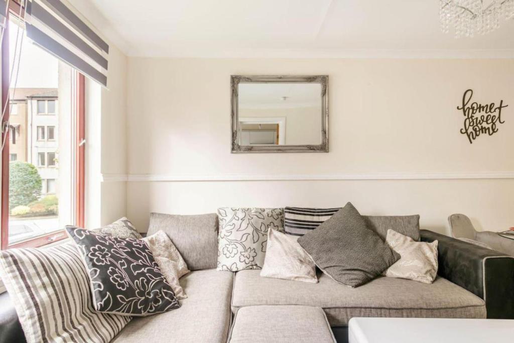 a living room with a couch and a mirror at The Summit Apartment Aberdeen City Central Perfect Short or long stay in Aberdeen