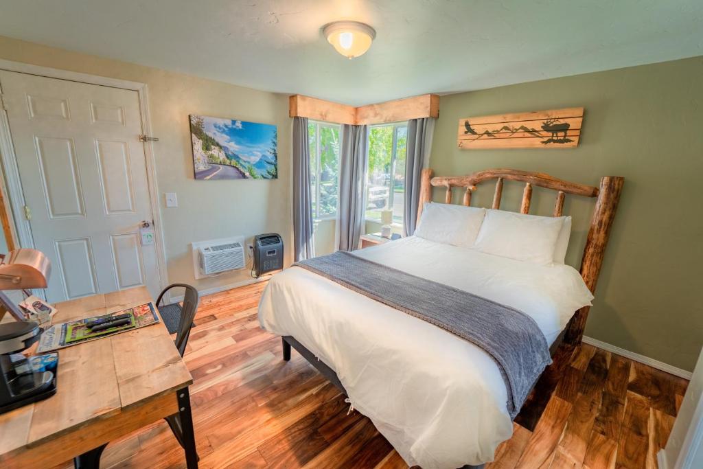 a bedroom with a bed and a desk and a window at Evergreen Motel in Libby