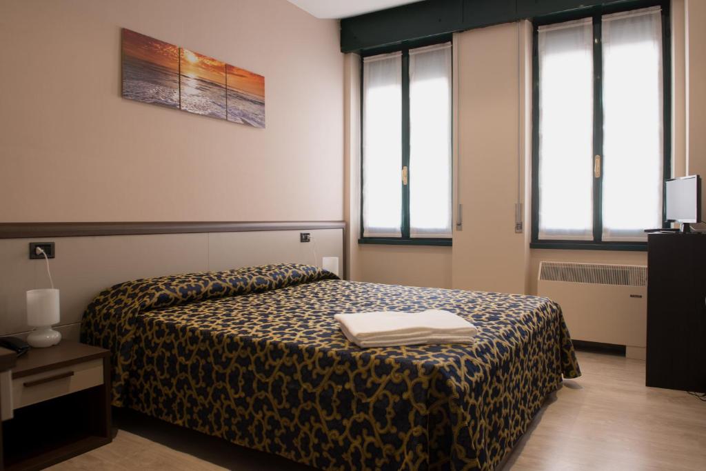 a hotel room with a bed with a blanket at Locanda San Fiorenzo in Fiorenzuola dʼArda
