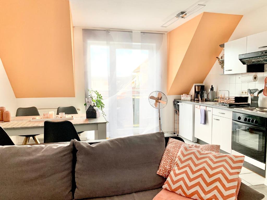 a living room with a couch and a kitchen at Eigenes Apartment im Herzen der Stadt mit Balkon und WLAN III in Cottbus