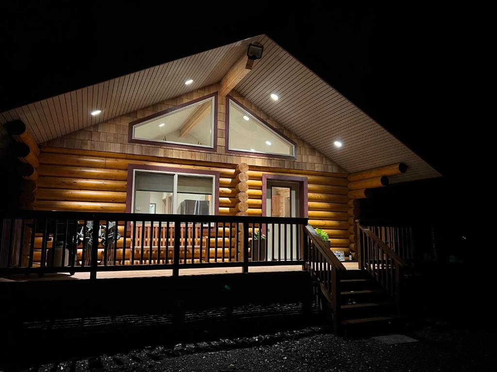 Cabaña de madera con una gran ventana en un porche en Clear creek cabin, en Seward