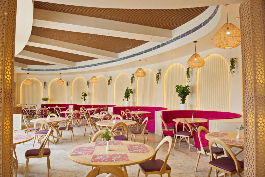 Wild Rose Resort and Spa في بوشكار: غرفة طعام مع طاولات وكراسي وأرجوانية