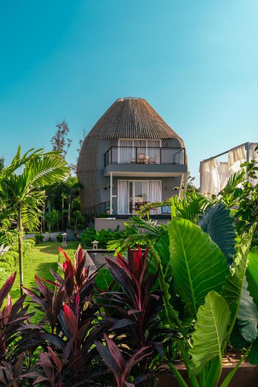a house with a thatched roof in a garden at LOTUS VILLA in Chennai