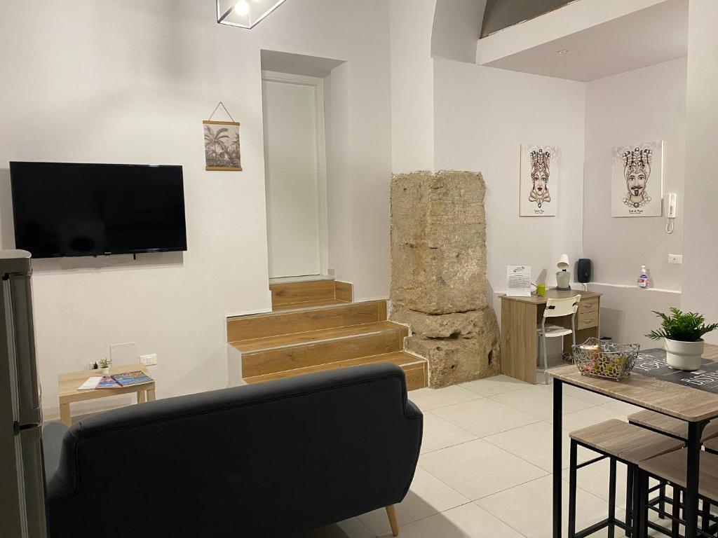 a living room with a tv on a wall at Zagara Holiday House Palermo Cattedrale in Palermo
