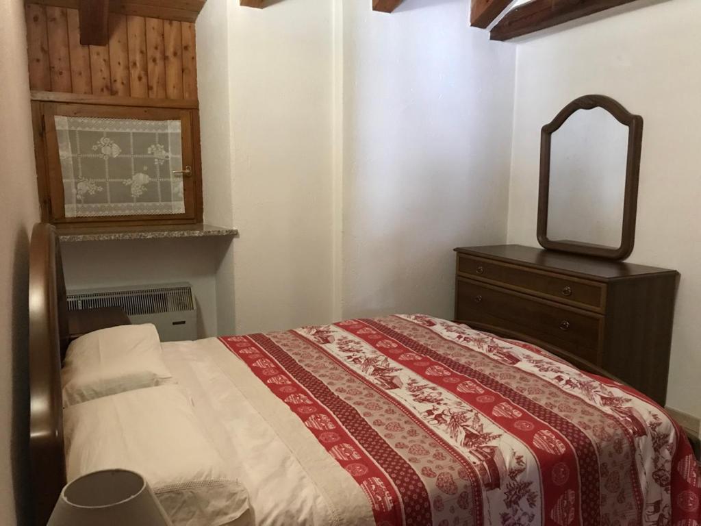 um quarto com uma cama com uma cómoda e um espelho em Chaillod 2 em Saint Nicolas
