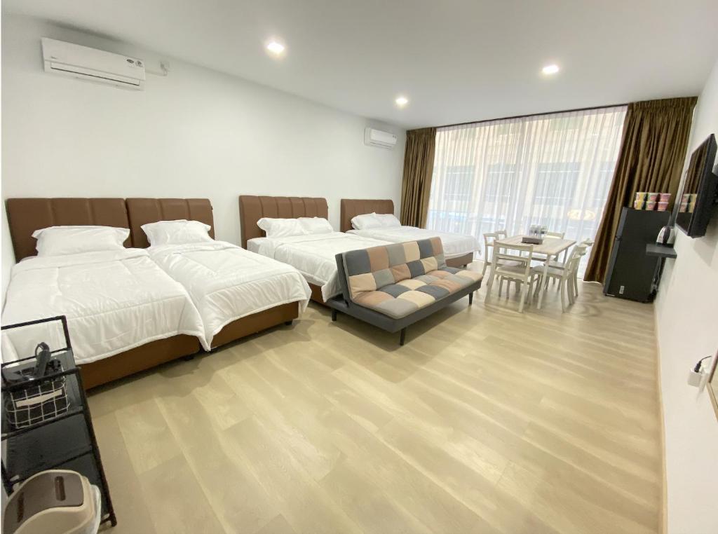 - une chambre avec deux lits, un canapé et une table dans l'établissement CN Homestay A1 Floor 1 at Nagoya Hill Mall, à Jodoh