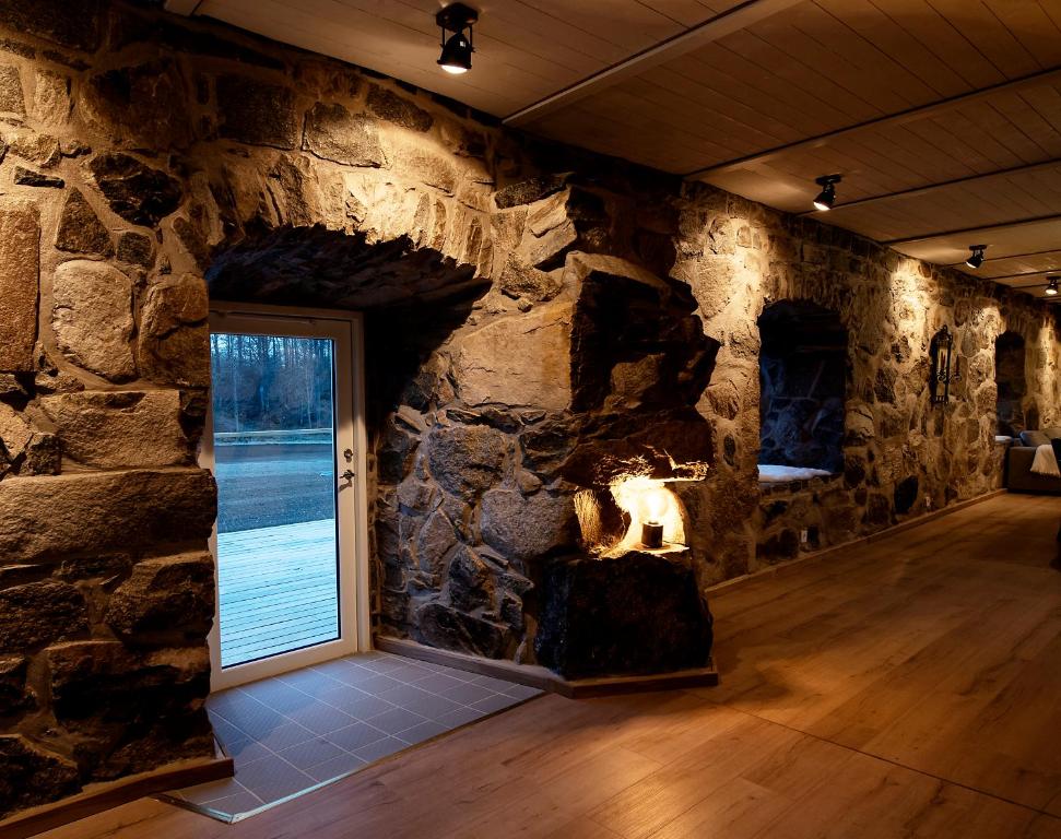 a room with a stone wall with a fireplace at Exclusive House in Olofström