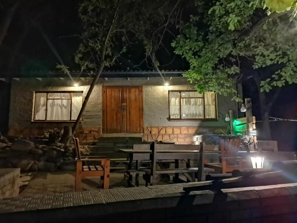 een huis met een tafel en stoelen 's nachts bij Cango Retreat Breathe in Oudtshoorn