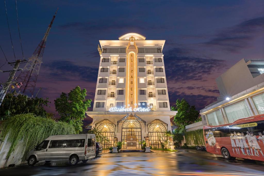 ELIZABETH HOTEL في Thu Dau Mot: مبنى فيه فان متوقف امامه