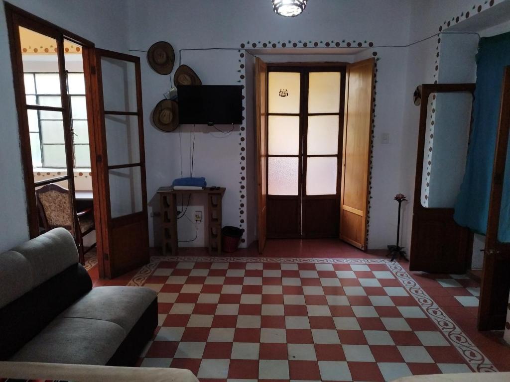 uma sala de estar com um piso e portas em xadrez em Cuarto Panchito ***Centro Histórico*** em Querétaro