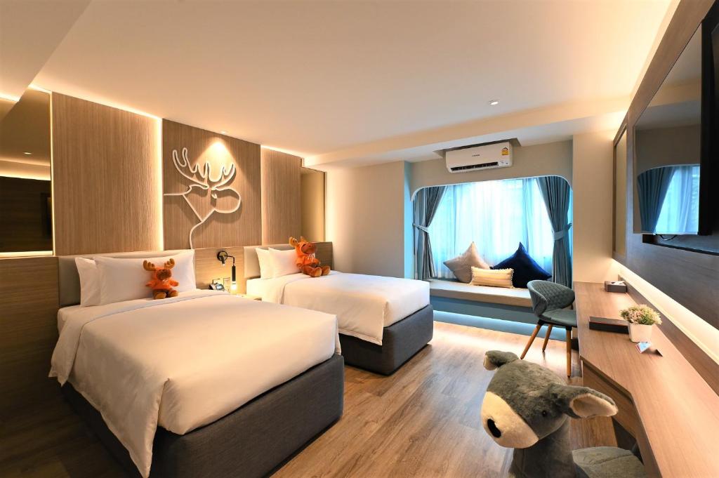 Postel nebo postele na pokoji v ubytování Moose Hotel Nimman