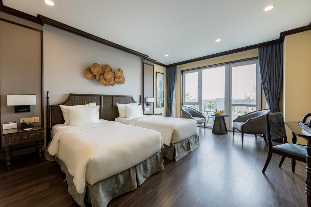 um quarto de hotel com duas camas e uma secretária em Ninh Binh Legend Hotel em Ninh Binh