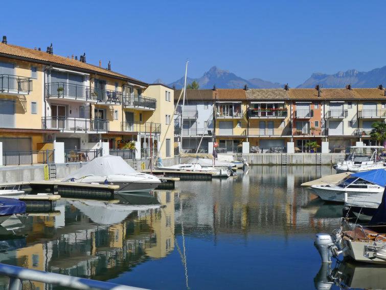 a group of boats docked in a marina with buildings at Superbe appartement dans la marina du Bouveret in Port-Valais
