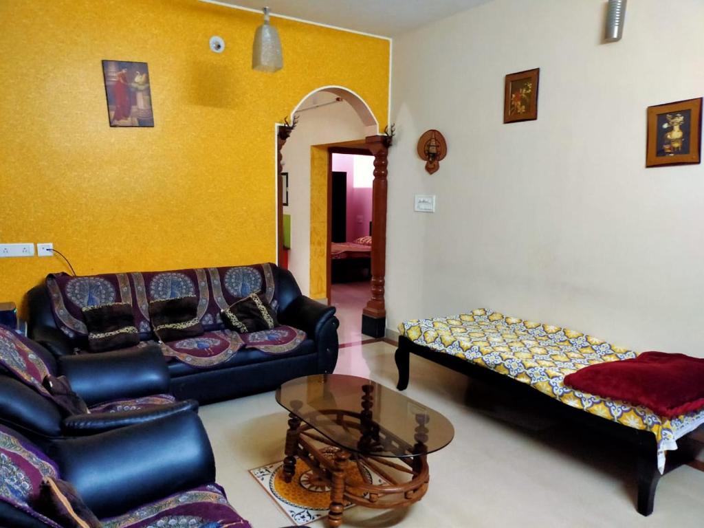 uma sala de estar com um sofá e uma mesa em Maanyatha Home Stay em Manipal