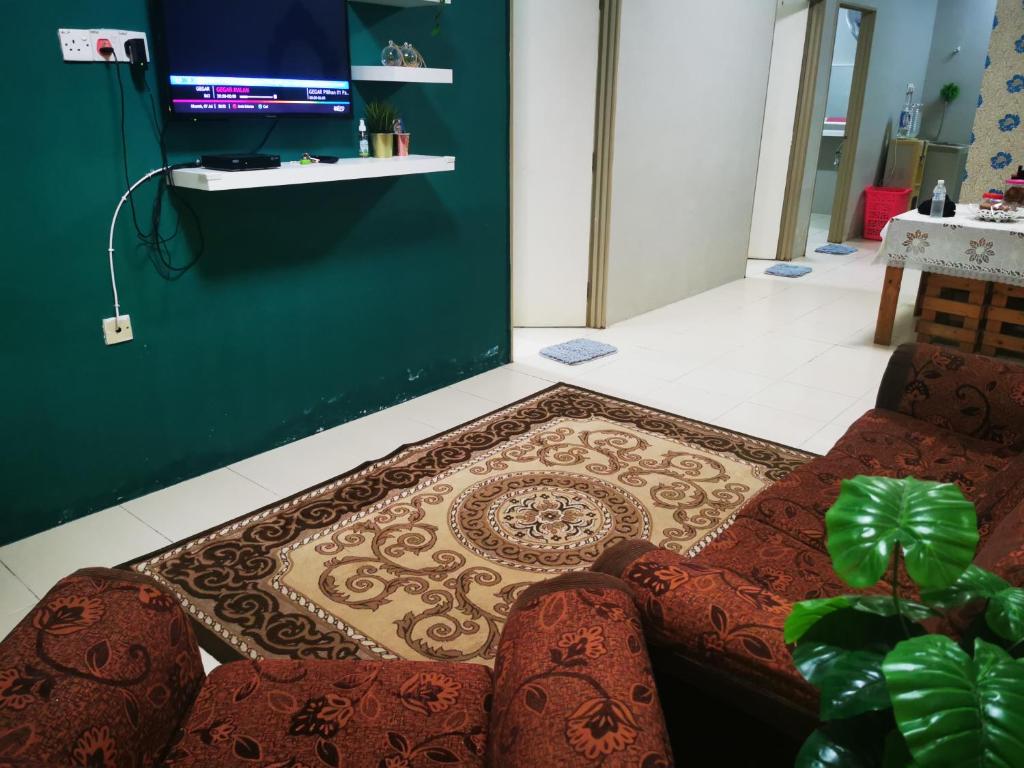 sala de estar con sofá y alfombra en BR Guesthouse Kuantan, en Kuantan