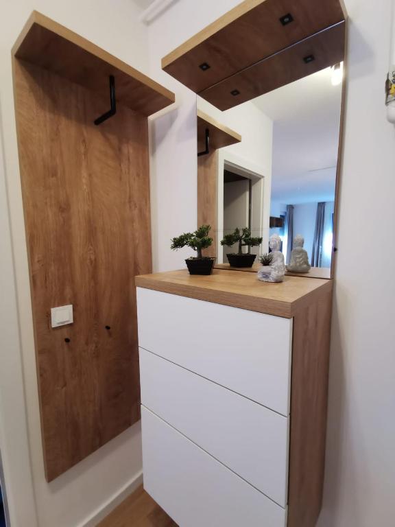 a bathroom with a white dresser and a mirror at Apartman ARIA in Zagreb