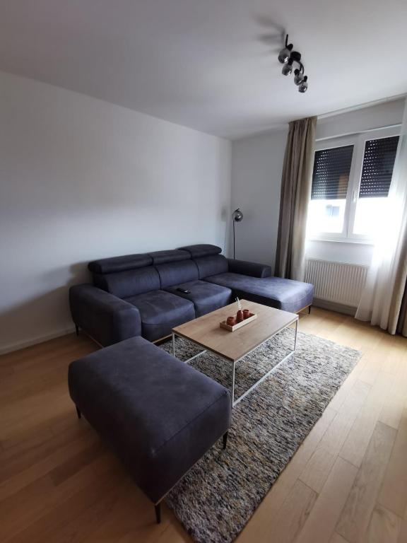 a living room with a blue couch and a coffee table at Apartman ARIA in Zagreb