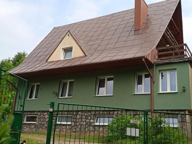 une maison verte avec un toit en gambrel dans l'établissement Usługi Turystyczne EKOTUR - Kraniec Świata, à Gołubie