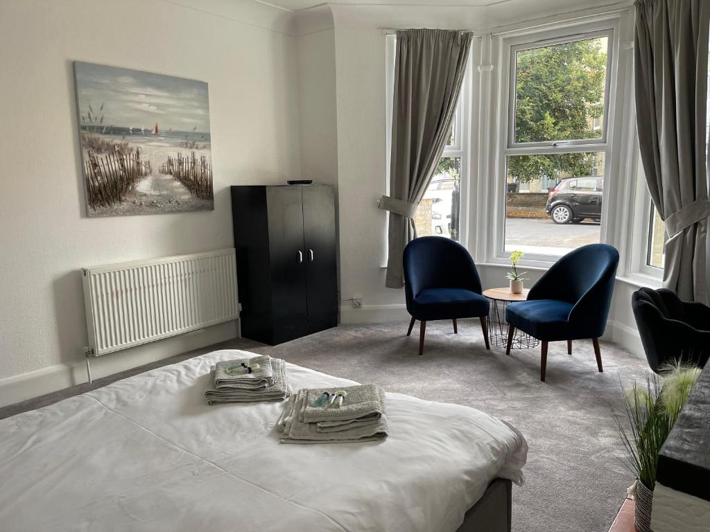 a bedroom with a bed and two chairs and a table at Impeccable 2-Bed Apartment in Eastbourne in Eastbourne