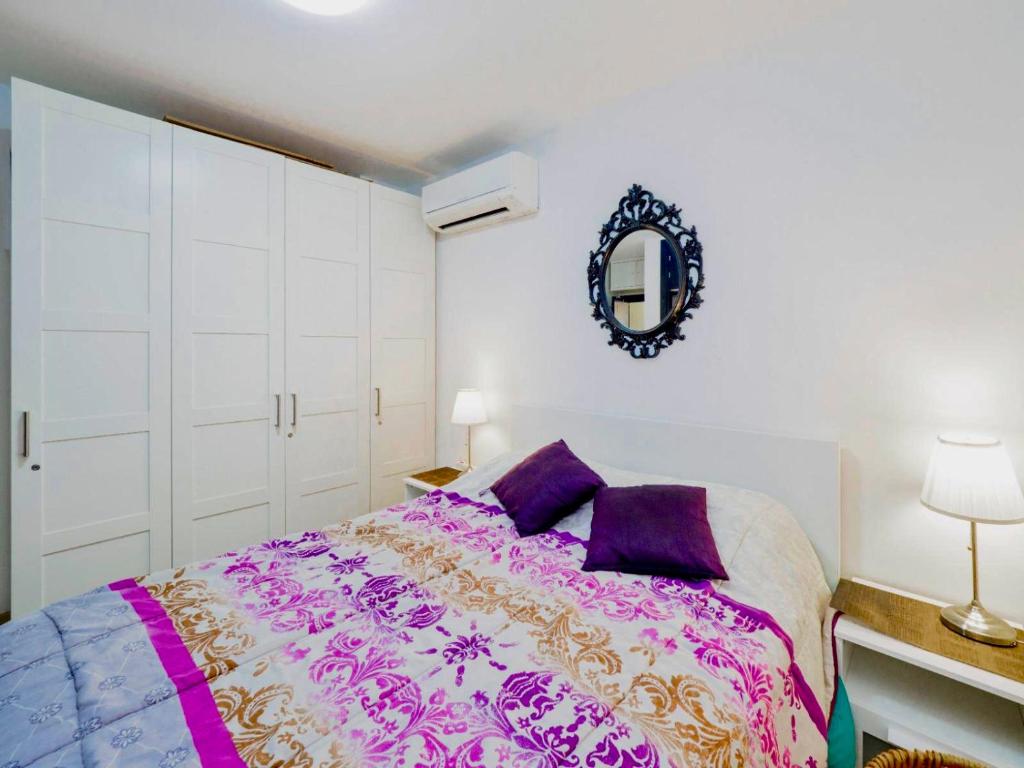 マルベーリャにあるHeart of Old Town Apartmentのベッドルーム1室(大型ベッド1台、紫色の枕付)