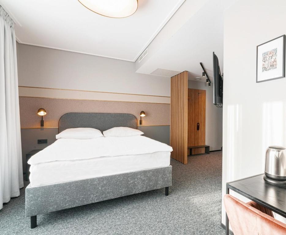 a bedroom with a bed and a tv in it at Rija Fonnental Design Hotel Tallinn in Tallinn