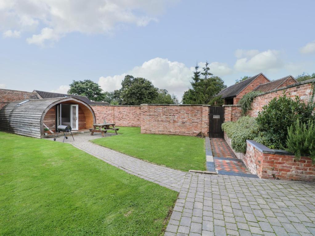 a garden with a brick wall and a picnic table at Willow in Uttoxeter