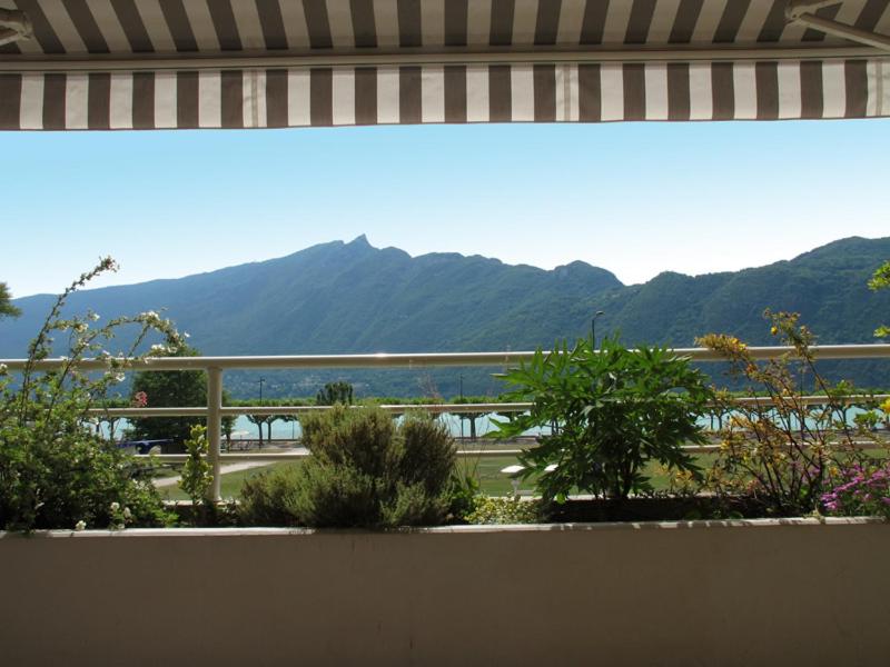 a balcony with a view of a road and mountains at 2P 4* 58m2 face au Lac in Aix-les-Bains