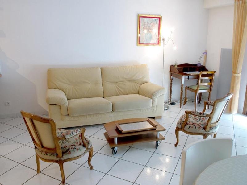 a living room with a couch and chairs and a table at 2P 4* 58m2 face au Lac in Aix-les-Bains