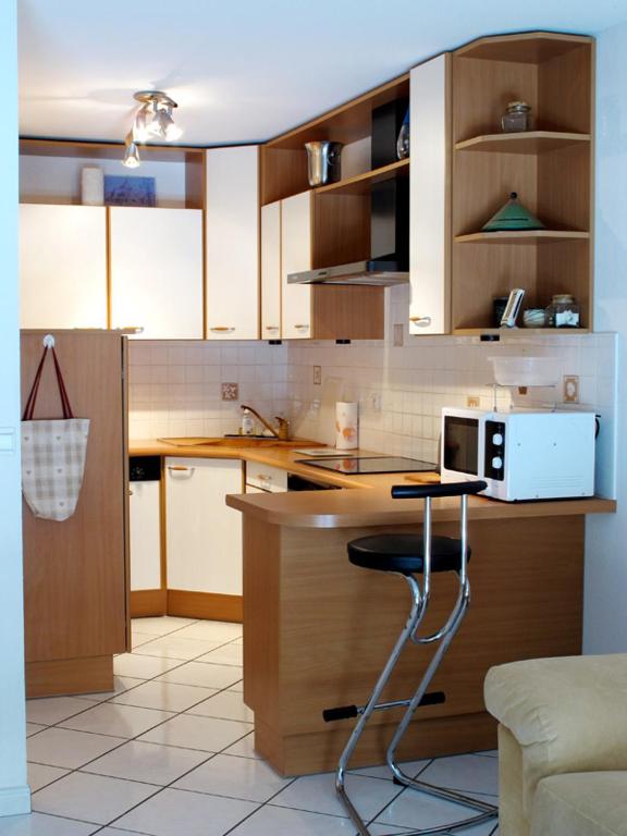 a kitchen with wooden cabinets and a counter top at 2P 4* 58m2 face au Lac in Aix-les-Bains