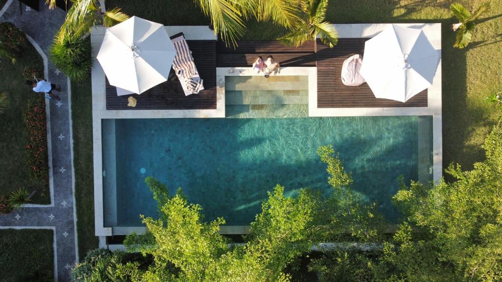 an overhead view of a swimming pool with umbrellas at Kaien Villas Gili Air in Gili Air
