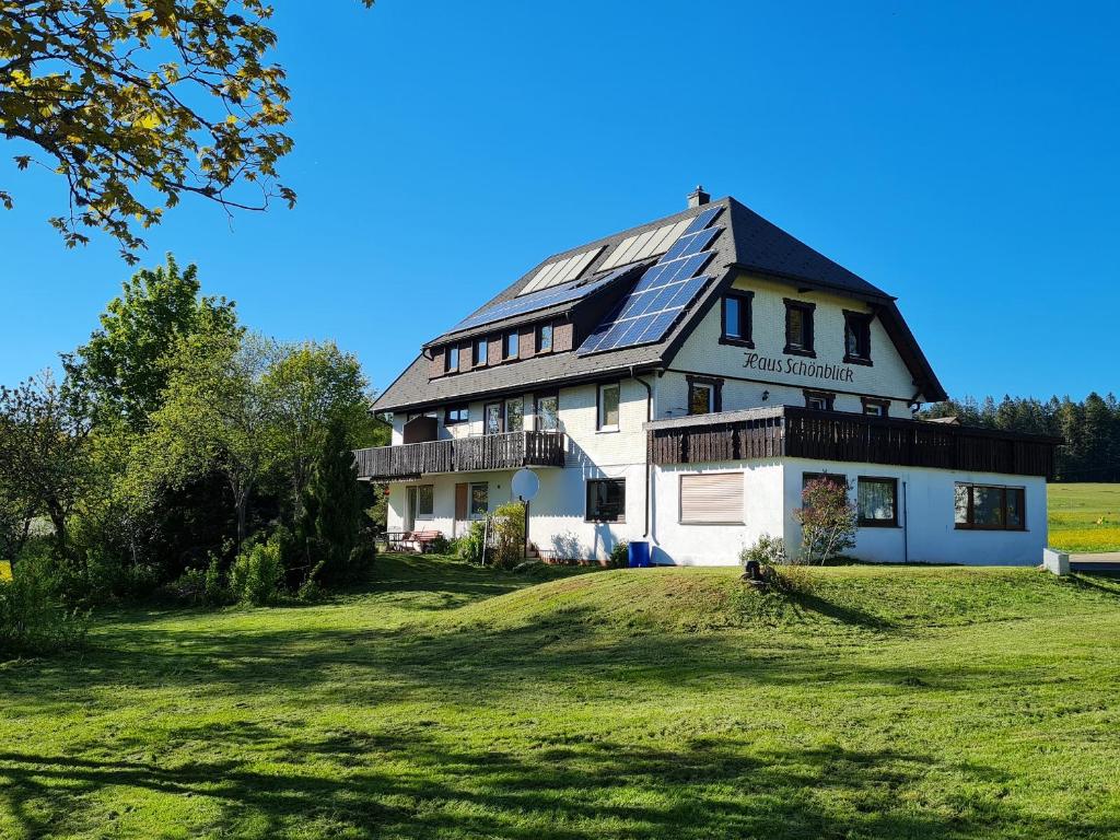 una casa con techo solar en un campo verde en Haus Schönblick, en Kniebis