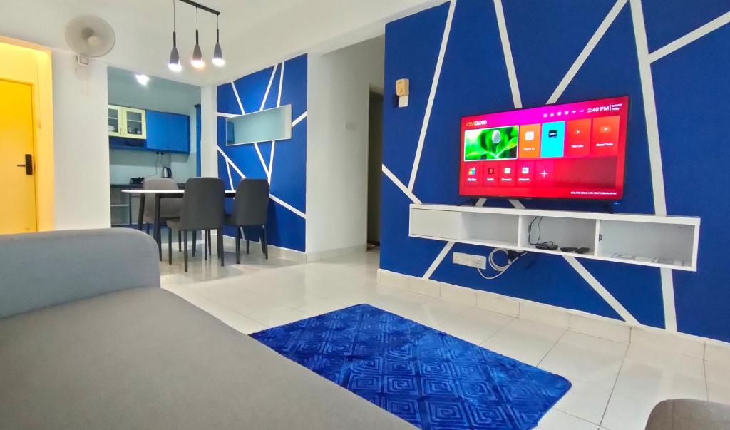 Cozzzzy Two Next to Axiata Arena, Bukit Jalil في كوالالمبور: غرفة معيشة مع تلفزيون على جدار أزرق