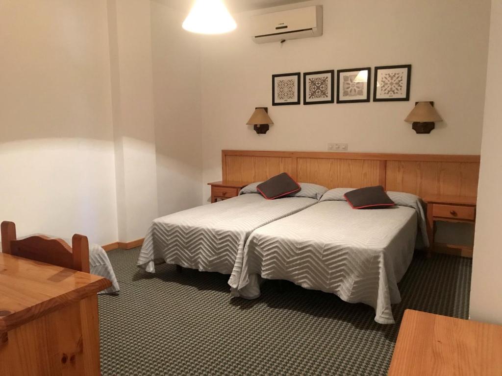 een hotelkamer met een bed en een tafel bij HOSTAL LA POSADA in Espirdo
