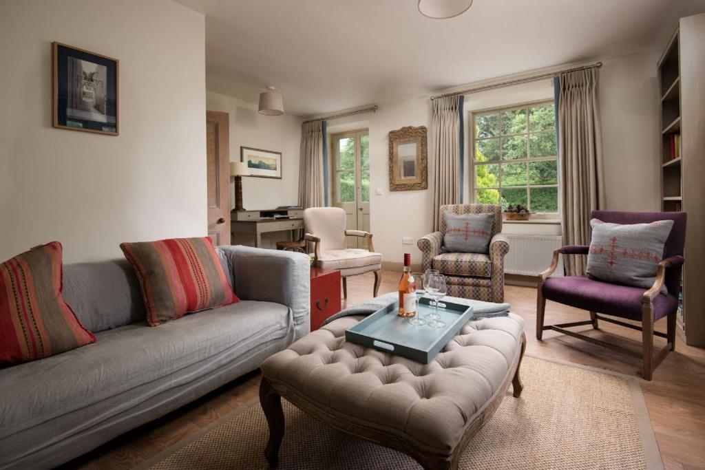 a living room with a couch and chairs and a table at Crailing Cottage in Jedburgh