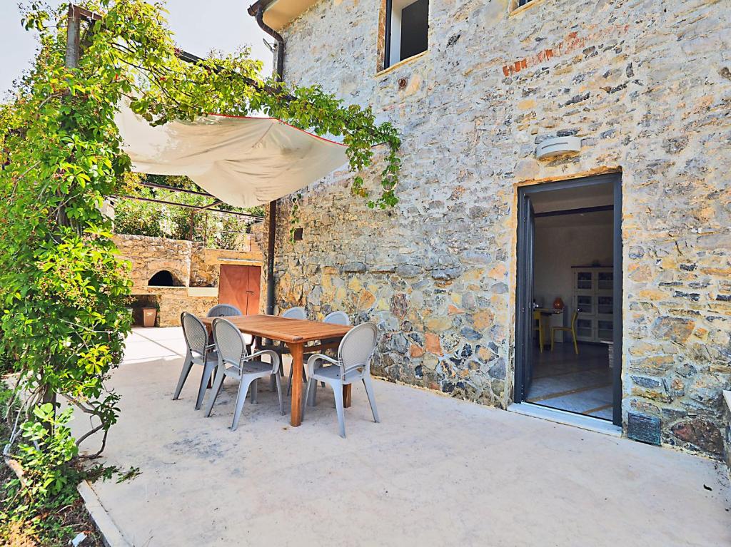 Une table et des chaises en bois sont disponibles sur la terrasse. dans l'établissement Casa Ginestra, à Lerici