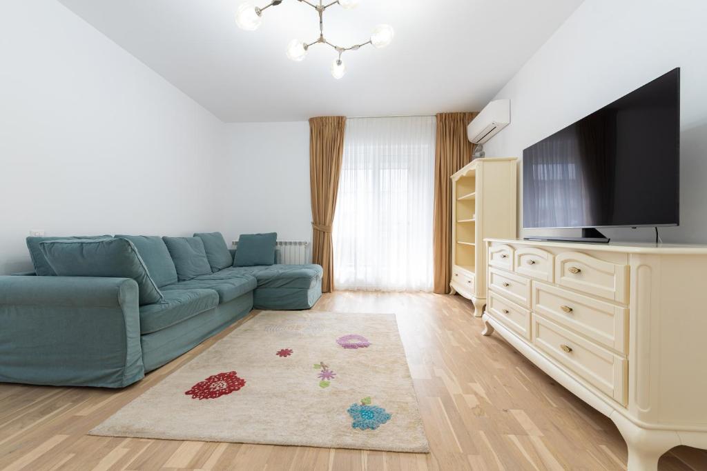 sala de estar con sofá azul y TV en Ines, en Bucarest