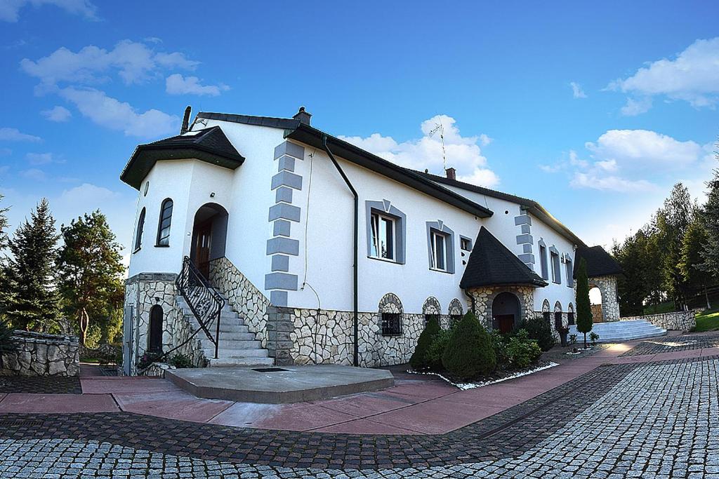 a large white house with a cobblestone street at Zajazd nad Zalewem Dzibice -Pensjonat, Agroturystyka in Dzibice